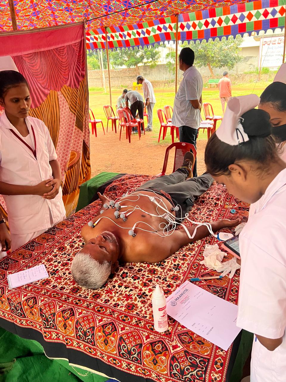 Healthcare workers carrying out an ECG screening at a health camp