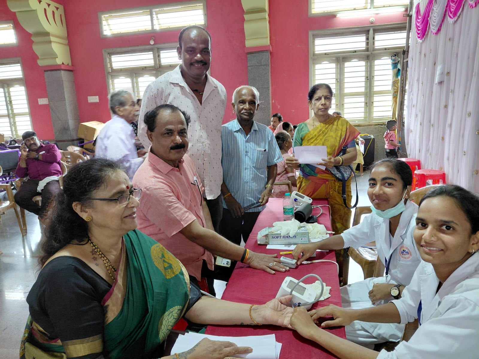 Healthcare workers conducting a blood pressure screening for community members